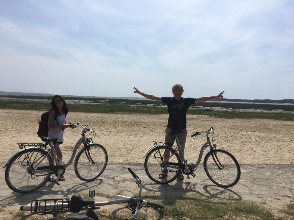 Xiomara Matathias and another student on bikes at the beach.
