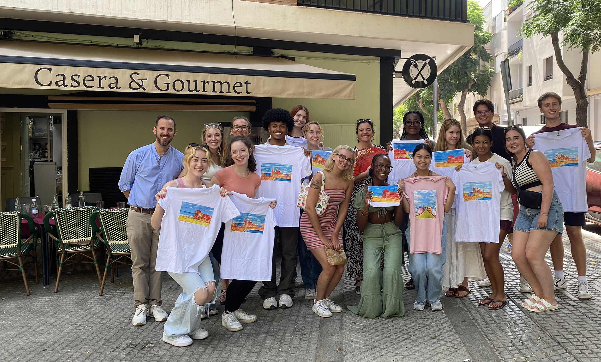 Students show their hand-painted tshirts standing in group on the sidewalk in Cadiz, Spain.