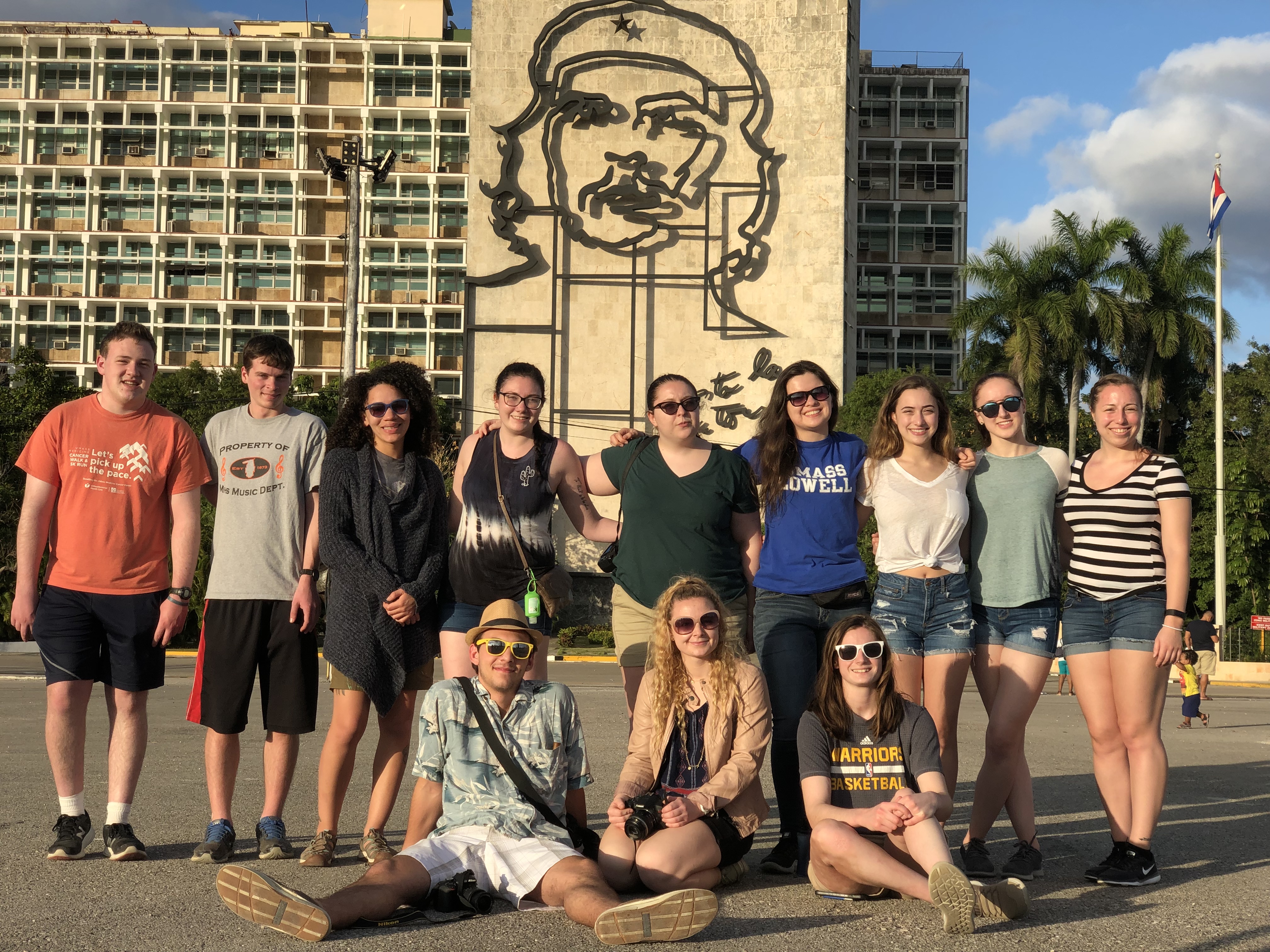 Honors students stand in Revolution Square, in front of a large portrait of Che Guevara.