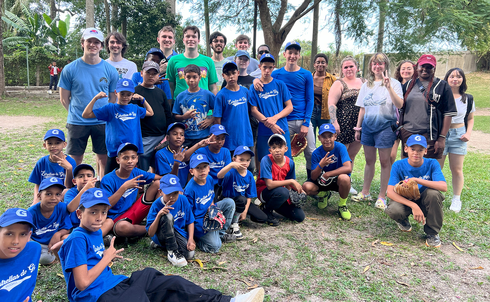 Students pose with Las Estrellas de Gigi, a Cuban youth baseball team.