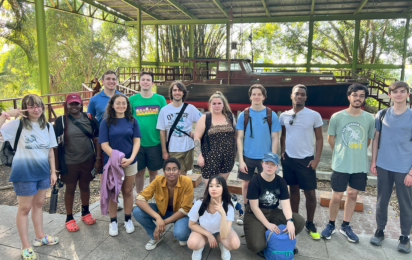 Students pose for a photo in front of Hemingway's boat, Pilar.