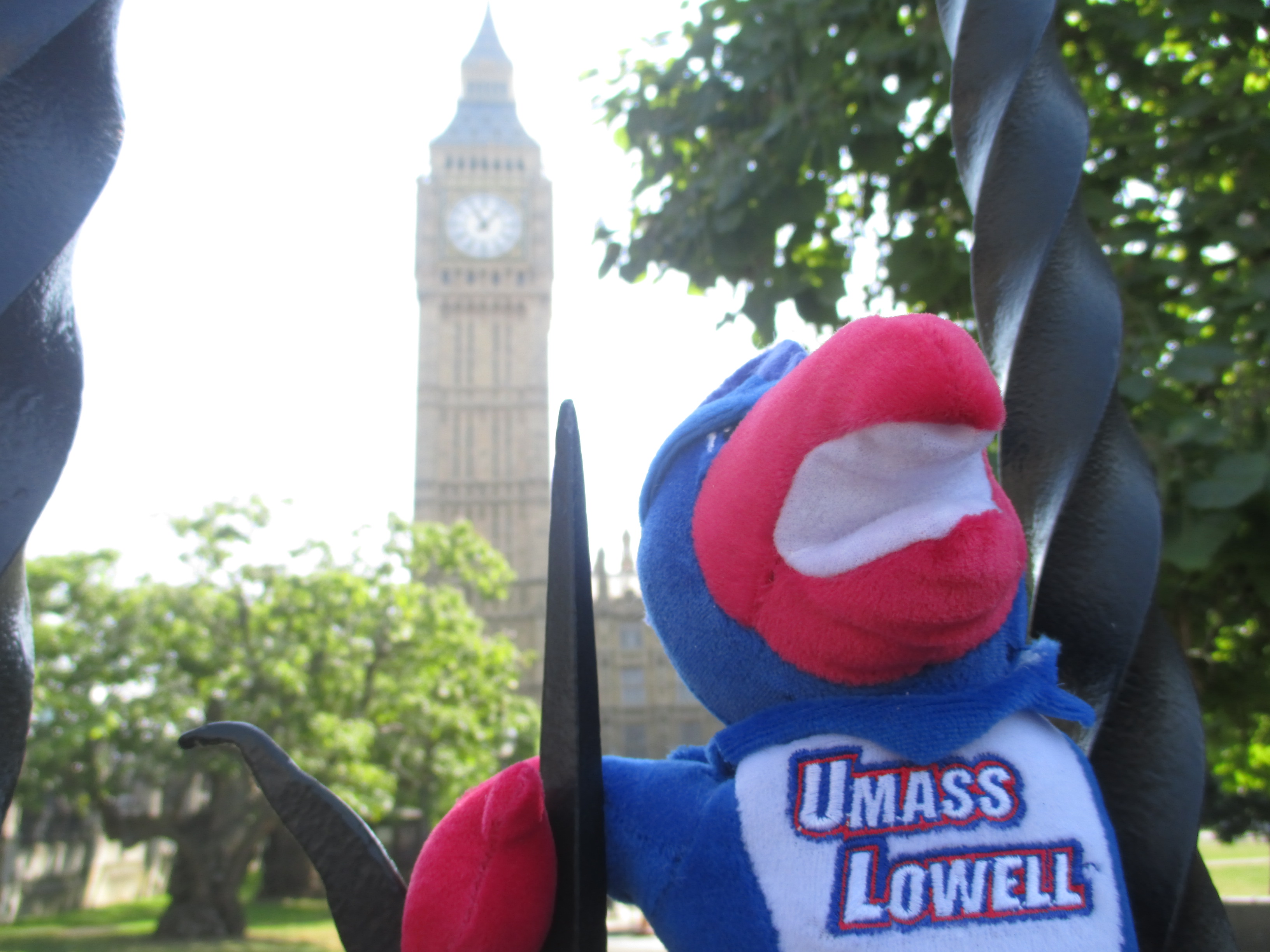 Stuffed animal of Rowdy the River Hawk - UMass Lowell’s mascot poses in front of Big Ben attraction
