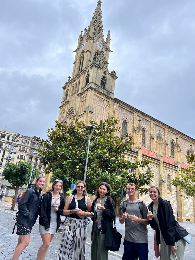 Students stand before a church while holding gelato in San Sebastian's neighborhood of Gros.