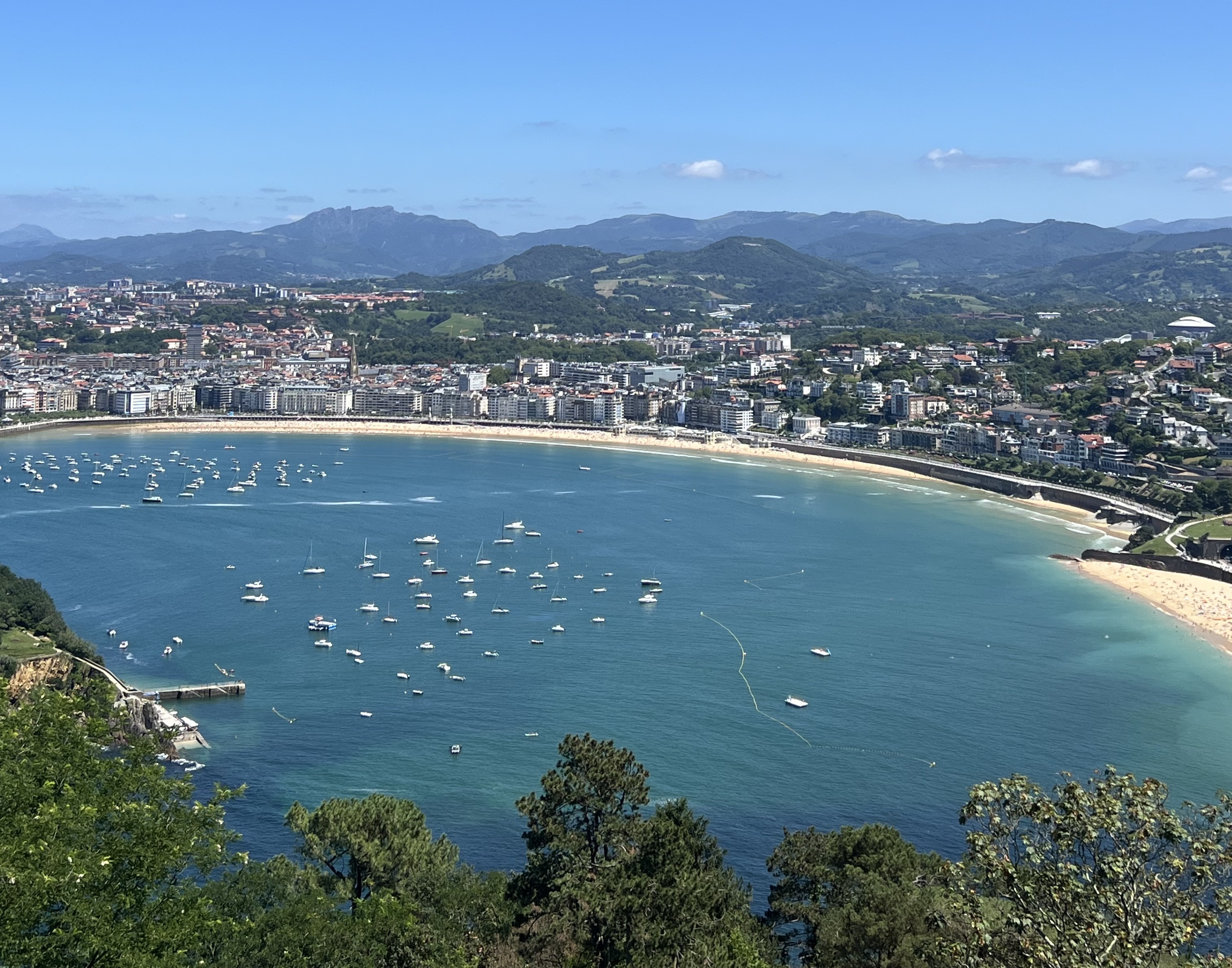 A view from above of the surrounding beaches, houses and water in San Sebastian, Spain.